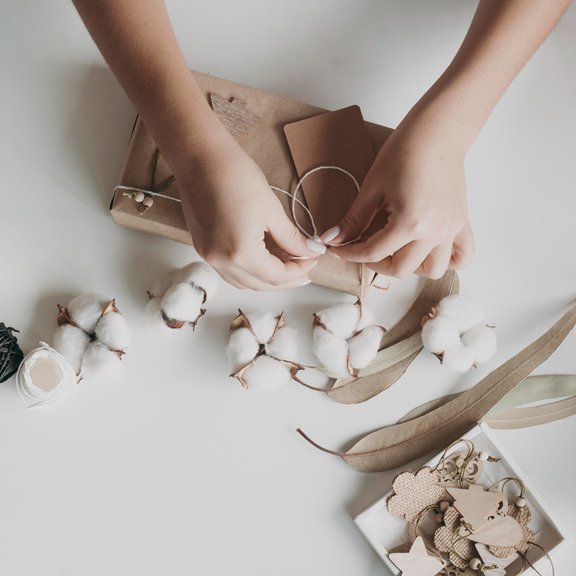 Indian artisan hands crafting sustainable home decor from natural materials like bamboo, jute, and reclaimed wood with fair trade practices